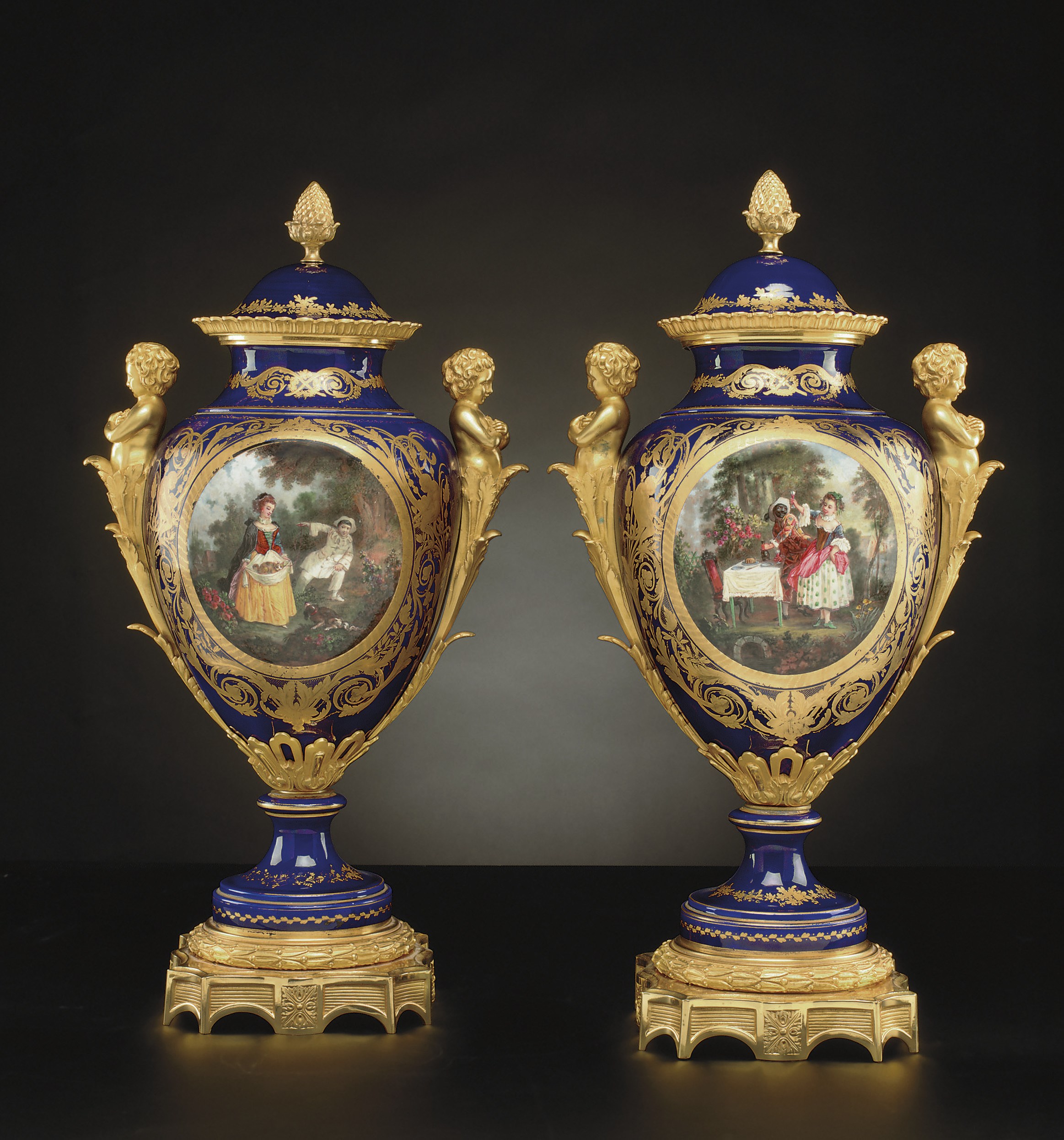 A PAIR OF ORMOLU-MOUNTED SEVRES STYLE COBALT-BLUE GROUND VASES AND TWO COVERS