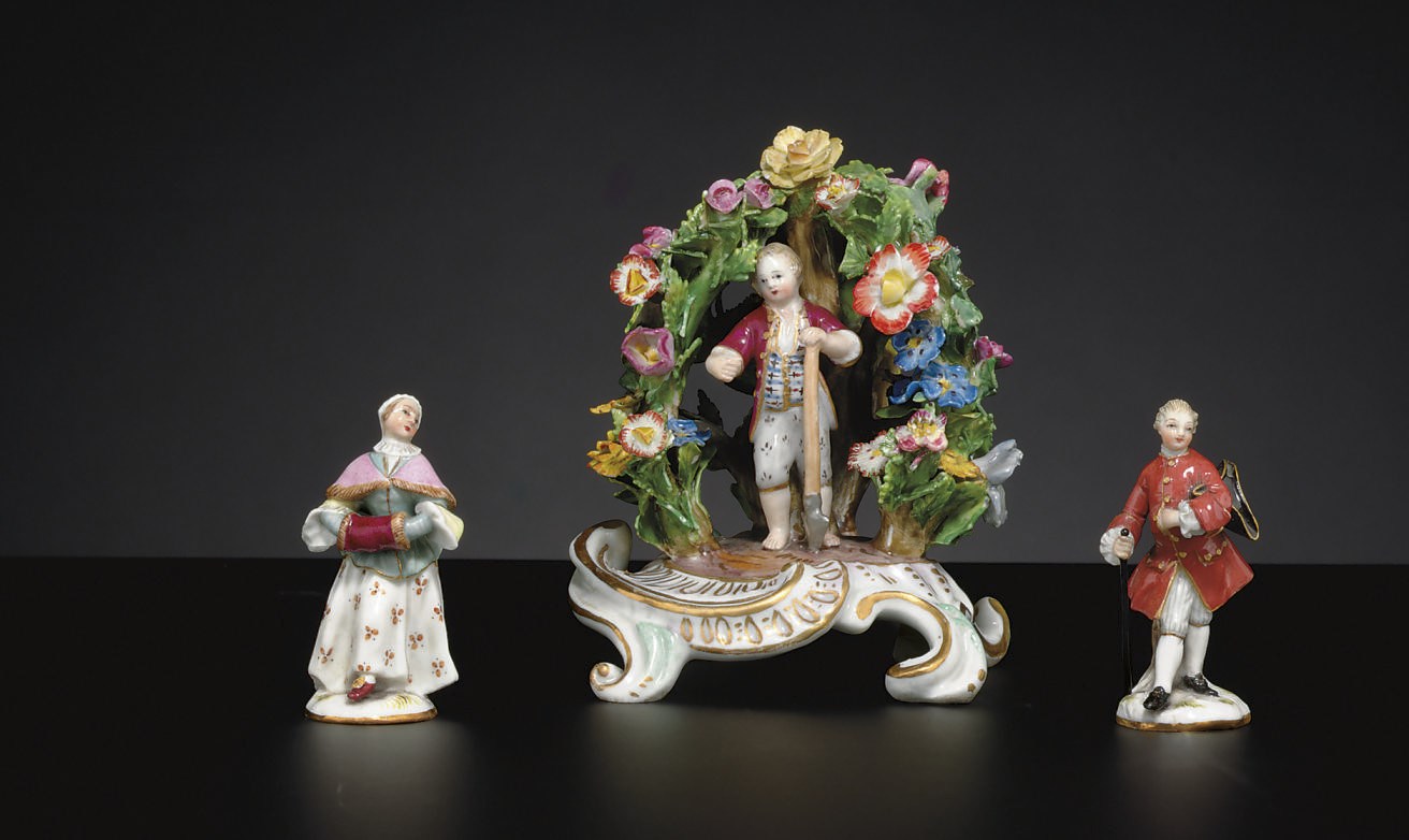 A MEISSEN MINIATURE ARBOR GROUP AND A PAIR OF MEISSEN FIGURES