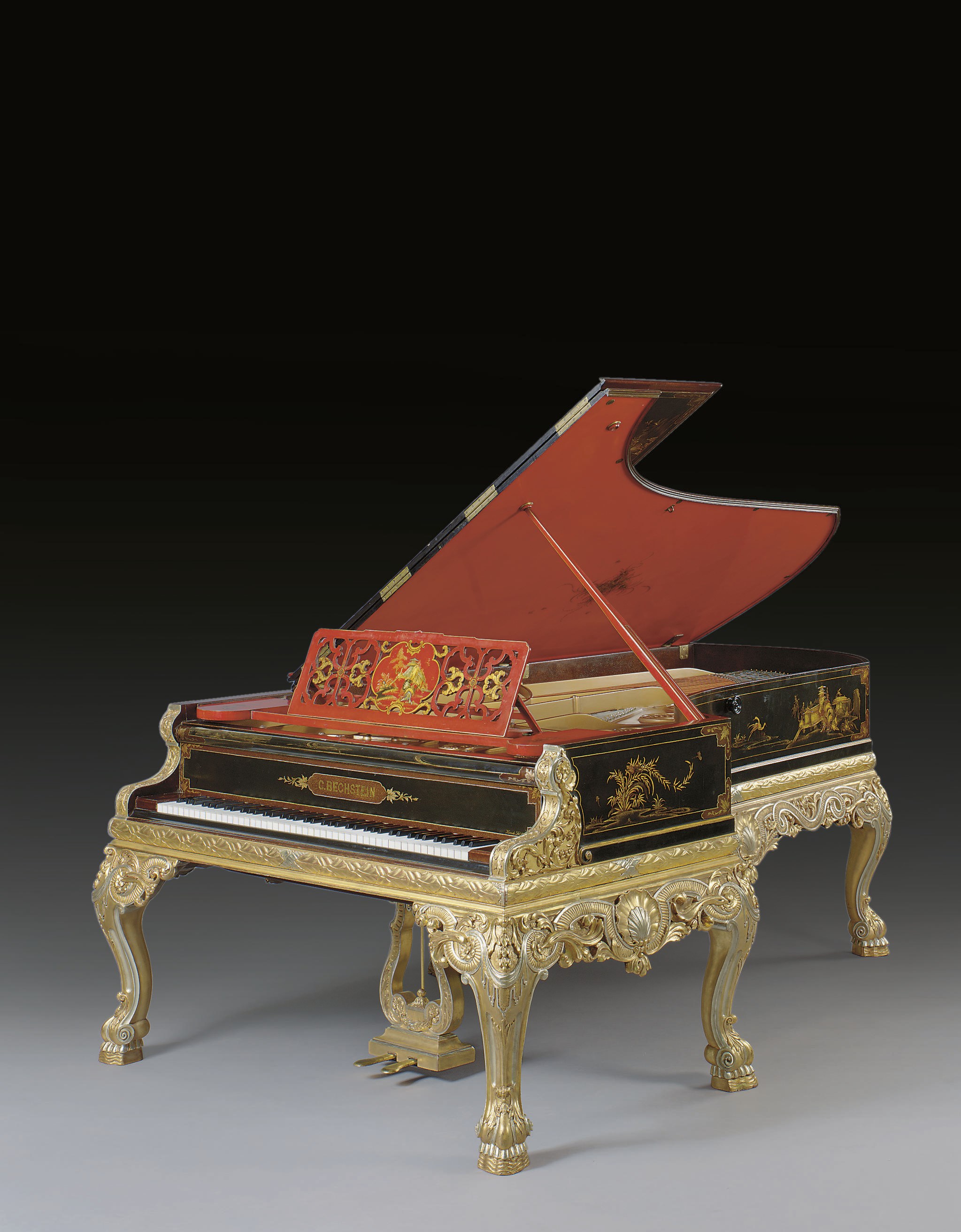 A Fine Berlin giltwood and black and red lacquered grand piano**