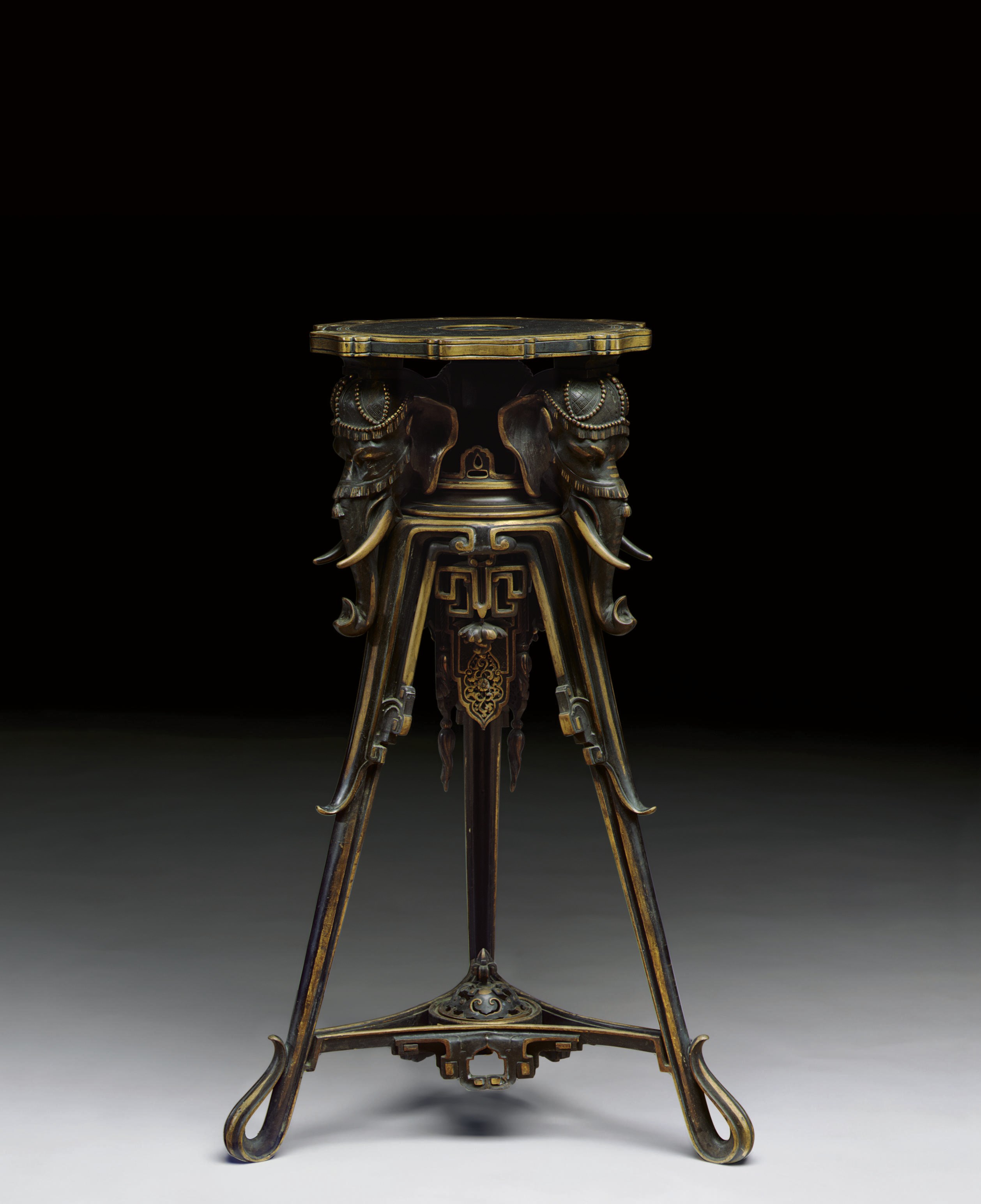 A FRENCH PATINATED AND PARCEL-GILT BRONZE TRIPOD TABLE-STAND