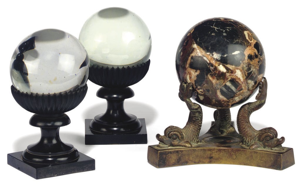 A PAIR OF VICTORIAN EBONY STANDS WITH GLASS SPHERES