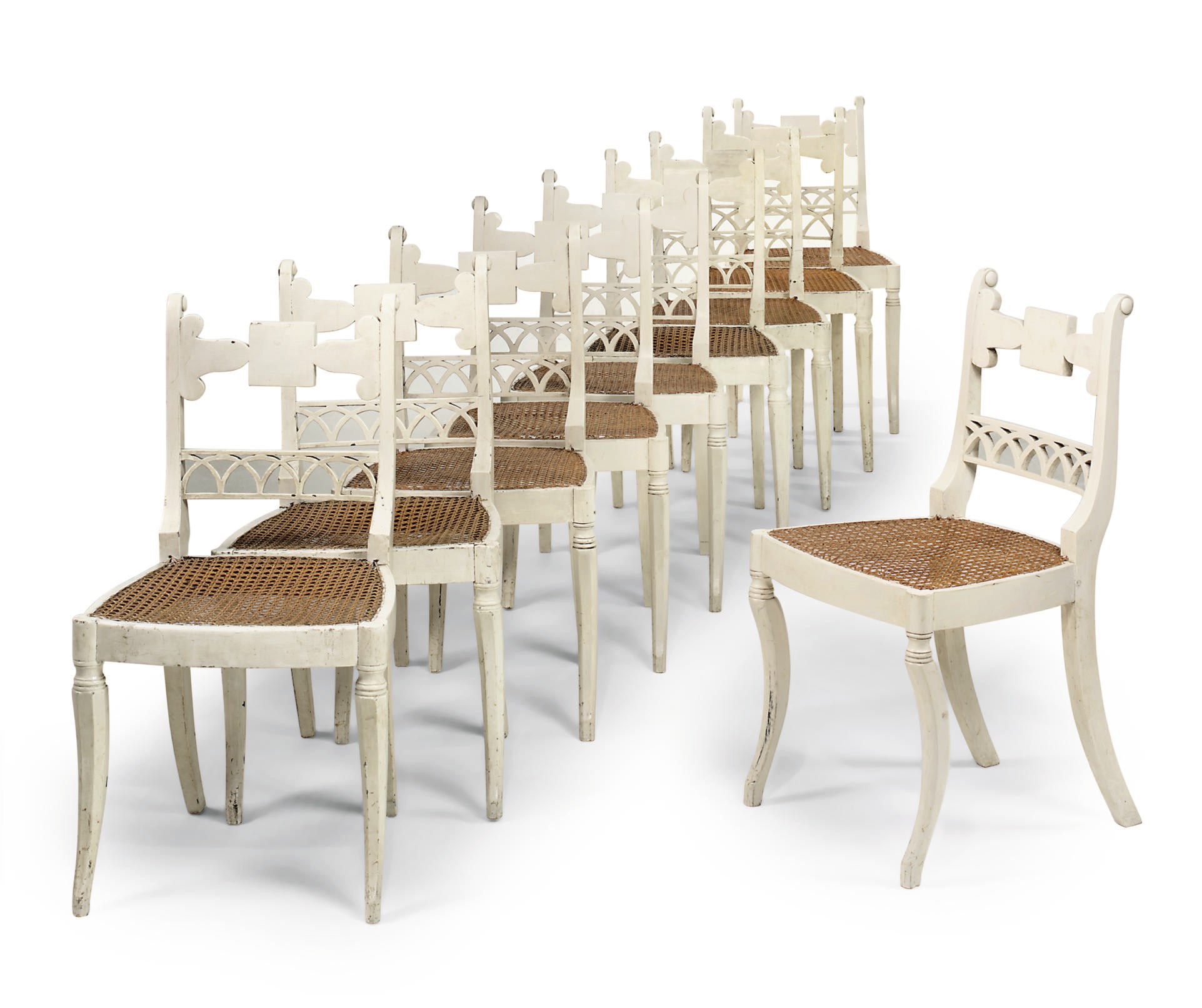 A SET OF TEN REGENCY WHITE PAINTED AND CANED DINING CHAIRS