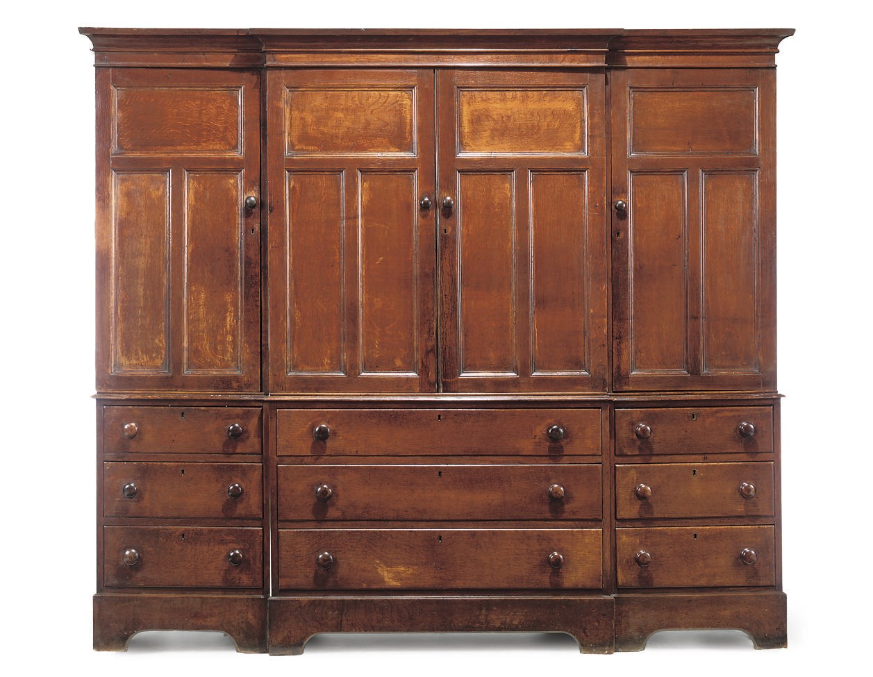 A VICTORIAN OAK PANELLED BREAKFRONT CUPBOARD