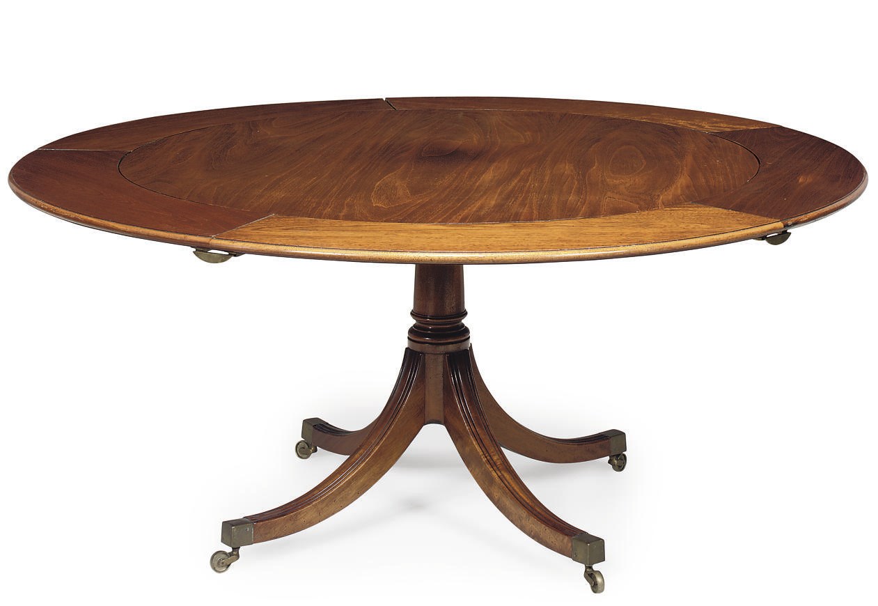 A MAHOGANY CIRCULAR EXTENDING DINING TABLE