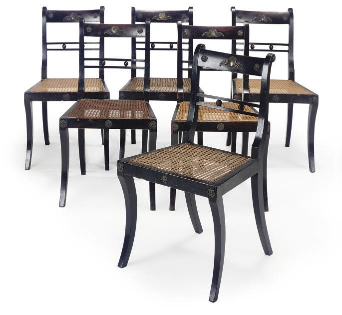 A SET OF SIX REGENCY EBONISED, GILT-METAL MOUNTED AND CANED DINING CHAIRS