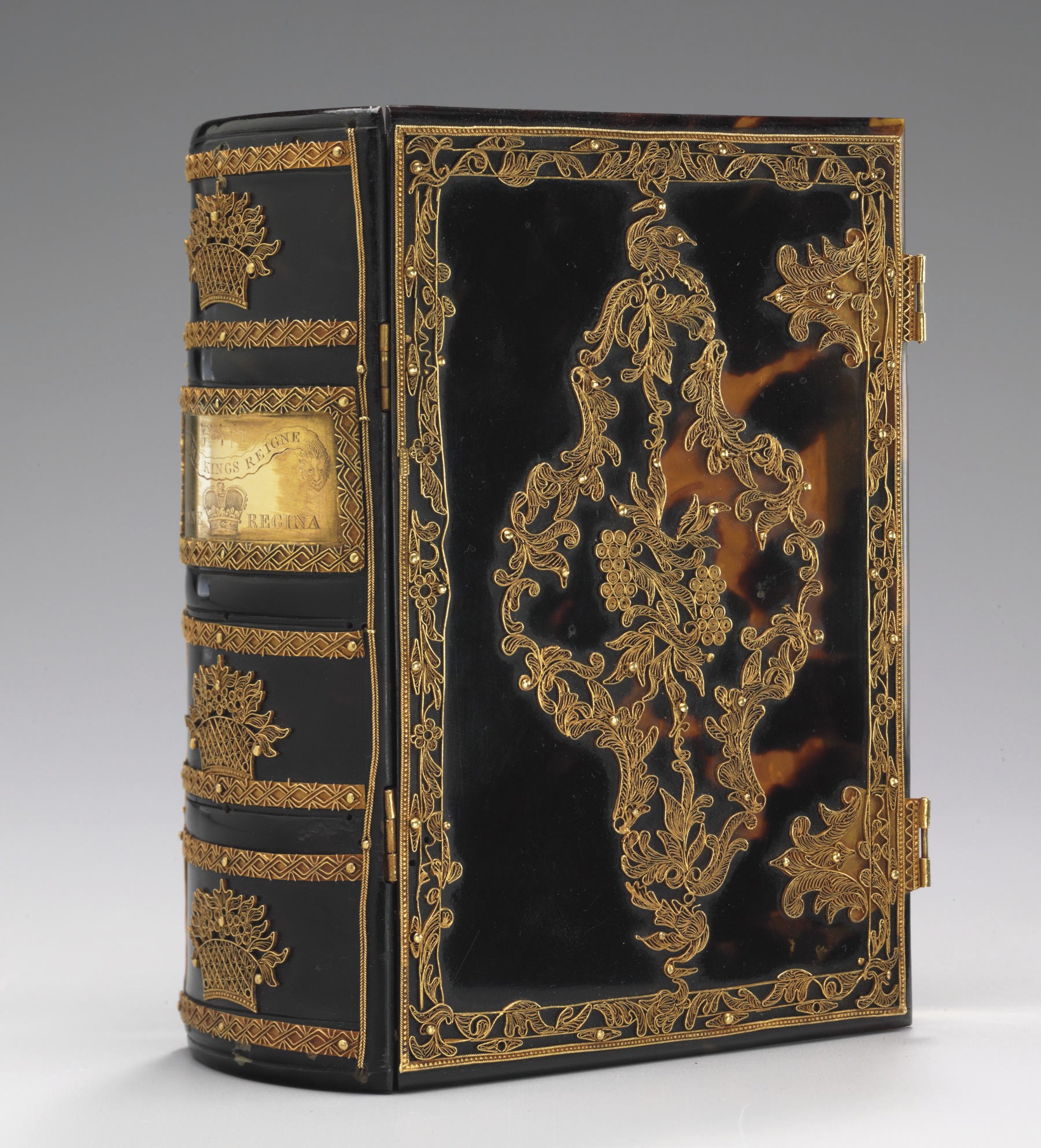 [BINDING--BOOK BOX FOR QUEEN ANNE]. CONTEMPORARY GOLD MOUNTED TORTOISE-SHELL FOLDING BOX FOR QUEEN ANNE, possibly Portuguese, covers with gold filigree decoration on a foliated rococo medallion enclosing bunches of grapes, edges covered in fine gold foil, spine with a gold plaque with engraved crown beneath the name of God in Hebrew and banner reading BY ME KINGS REIGNE, ANNE REGINA engraved on bottom, three filigree baskets of flowers on spine. Provenance: Henrietta M.S. Stuart (gift card tipped to flyleaf: "Henrietta M.S. Stuart from her affectionate husband William Stuart. 9th August 1852. The 31st Anniversary of their wedding"); sold Parke-Bernet, 7 October 1955 (sale of silver, porcelain and decorative arts); Cornelius J. Hauck, purchased from Emil Offenbacher, 10 October 1955.