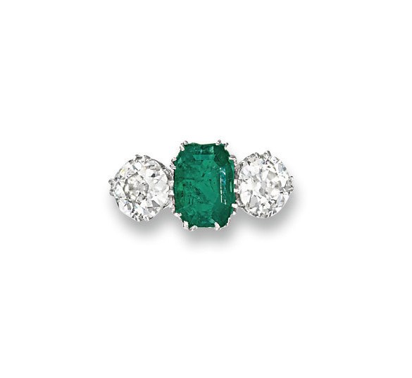 AN EARLY 20TH CENTURY EMERALD AND DIAMOND THREE-STONE RING