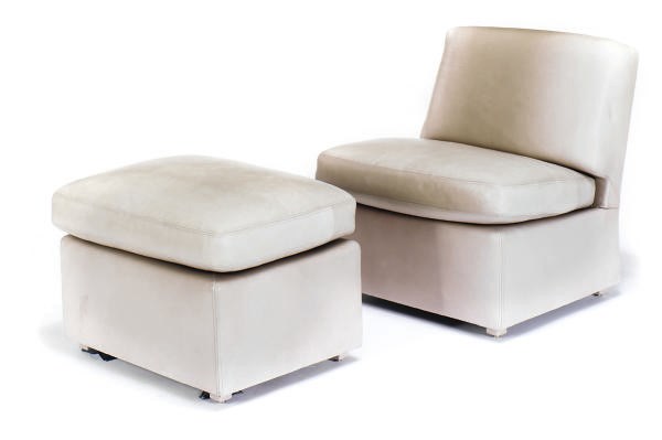 A LEATHER UPHOLSTERED CHAIR AND OTTOMAN,