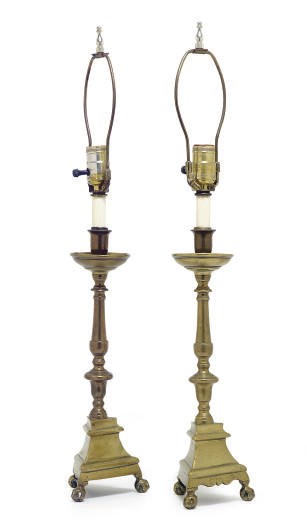 A PAIR OF BRASS TRIPOD CANDLESTICKS MOUNTED AS TABLE LAMPS,
