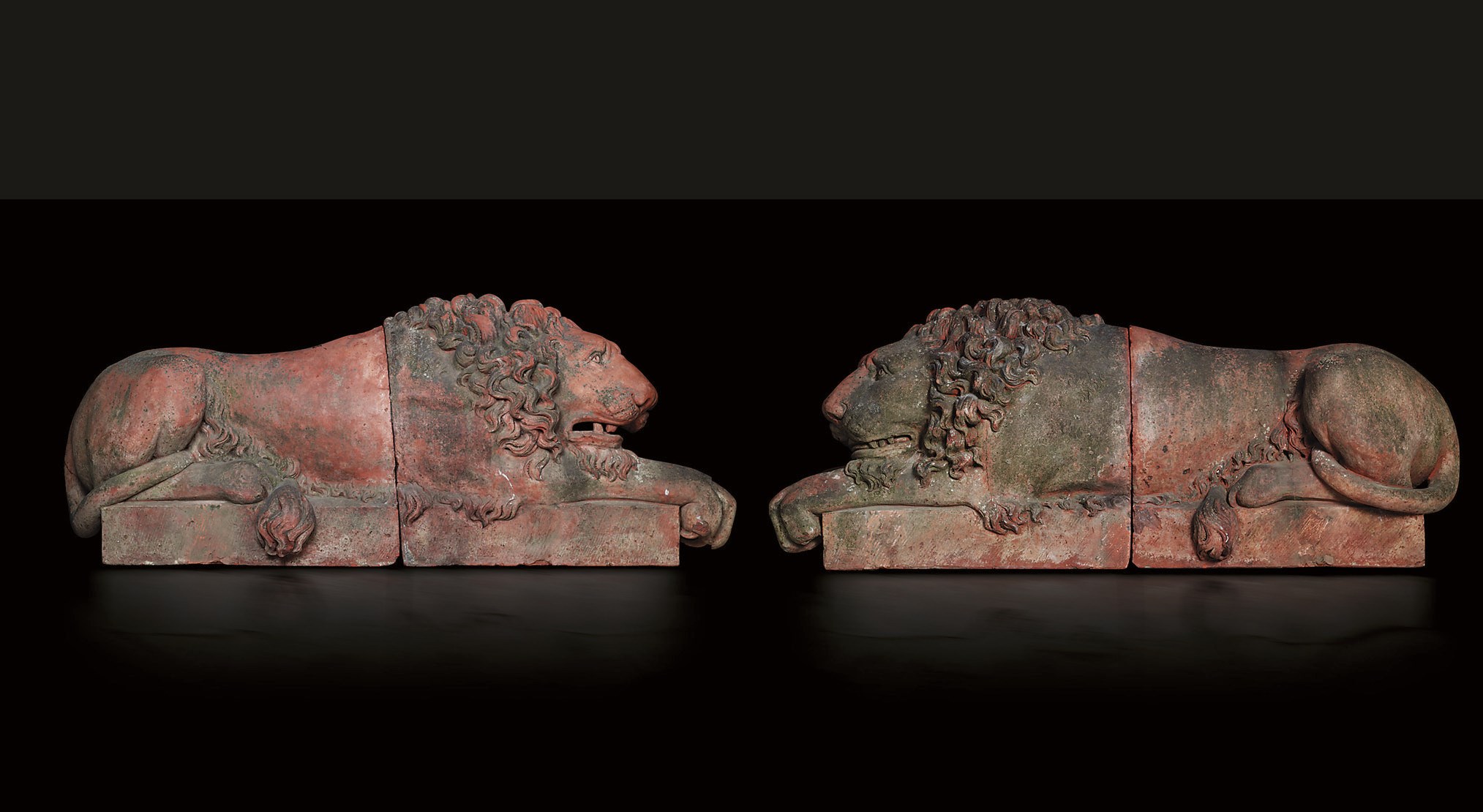 A PAIR OF RECLINING TERRACOTTA LIONS