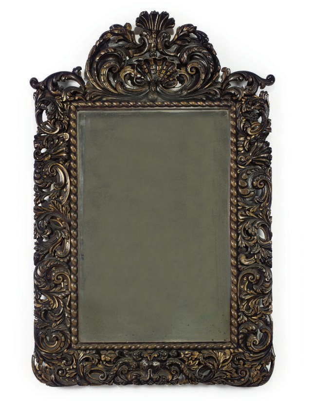 A STAINED OAK AND PARCEL GILT MIRROR