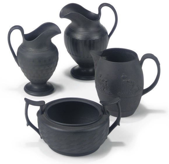THREE SHORTHOSE BLACK BASALT MILK-JUGS AND A SUGAR-BOWL