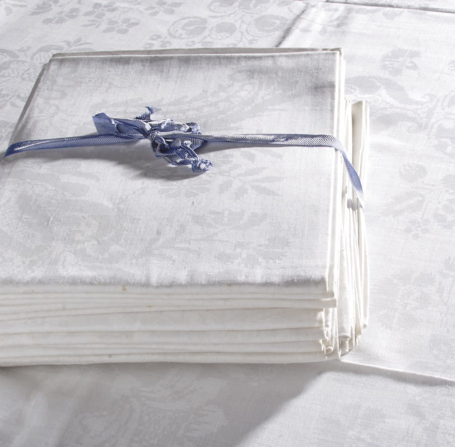 A WHITE LINEN DAMASK TABLECLOTH AND EIGHTEEN MATCHING NAPKINS