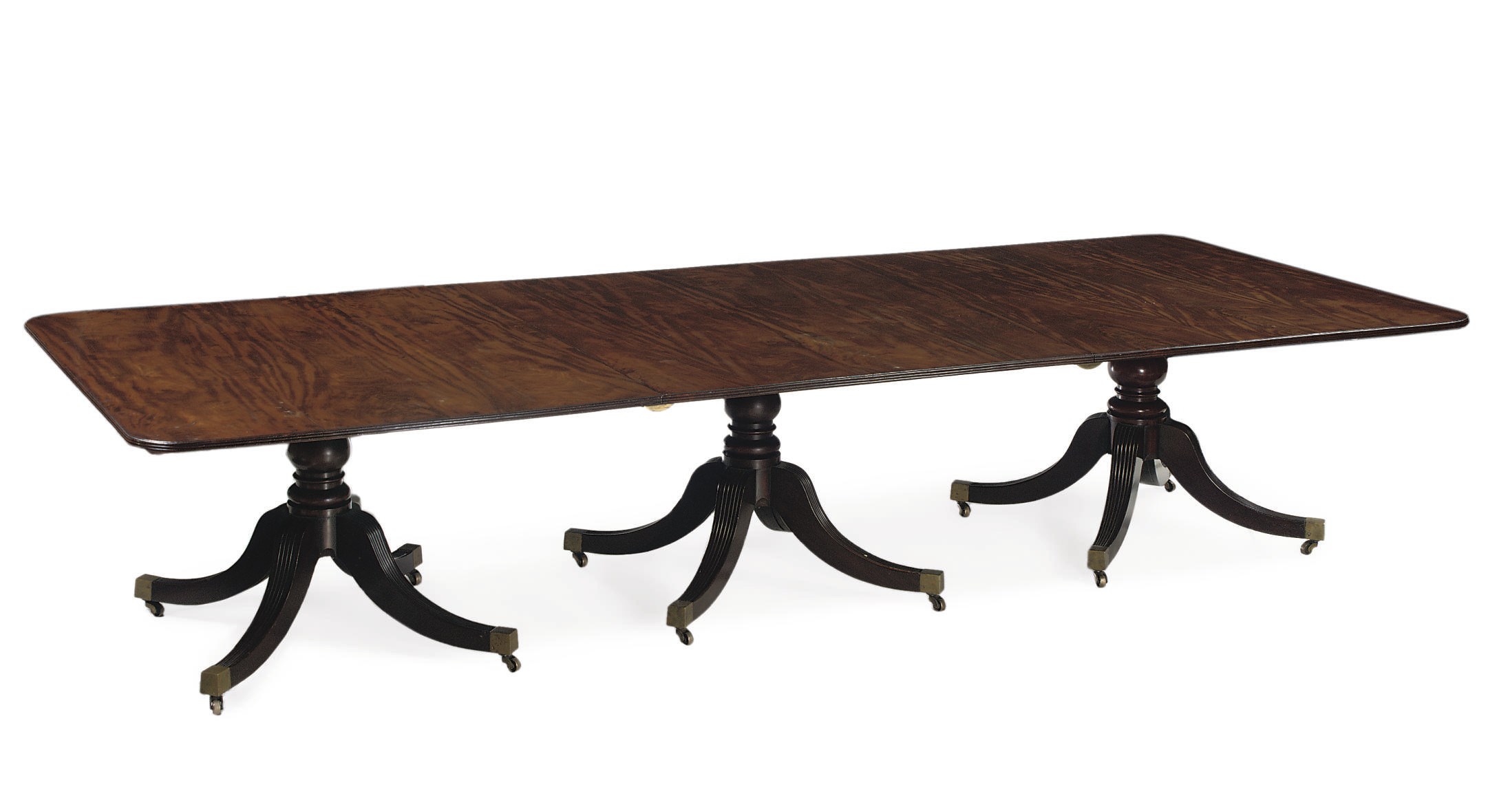 A REGENCY MAHOGANY THREE-PEDESTAL EXTENDING DINING TABLE