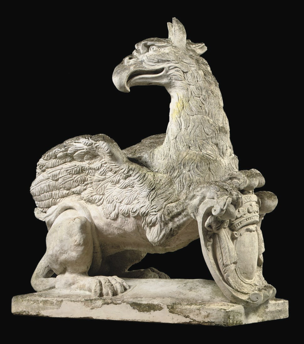 A COMPOSITE STONE FIGURE OF A GRIFFIN HOLDING A CROWNED COAT OF ARMS
