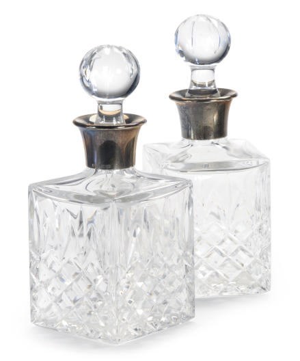 A SET OF EIGHT ELIZABETH II SMALL SILVER MOUNTED CUT GLASS DECANTERS AND STOPPERS,