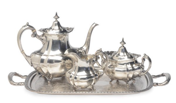 AN AMERICAN SILVER THREE PIECE TEA SET, A SILVER-MOUNTED CUT GLASS DECANTER, AND A SILVER-PLATED TRAY,
