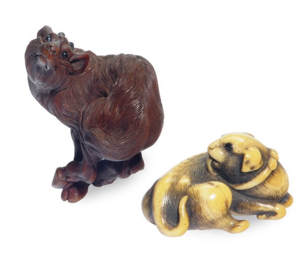 A JAPANESE CARVED IVORY DOG-FORM NETSUKE AND A WOOD MODEL OF A GOAT,