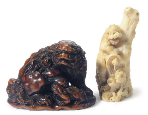 TWO JAPANESE IVORY CARVED FIGURES OF BUDDHISTIC LIONS,**