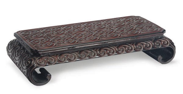 A SMALL JAPANESE BLACK AND RED LACQUERED LOW TABLE WITH SCROLL FEET,