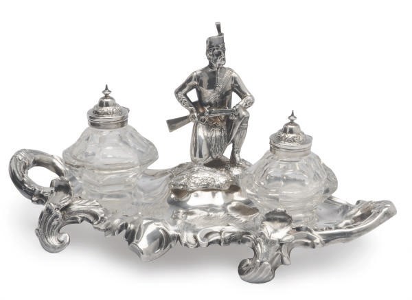 AN ENGLISH SILVER-PLATED INKSTAND MODELED WITH A KNEELING HIGHLANDER,