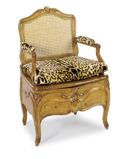 A FRENCH PROVINCIAL WALNUT AND CANED BIDET,