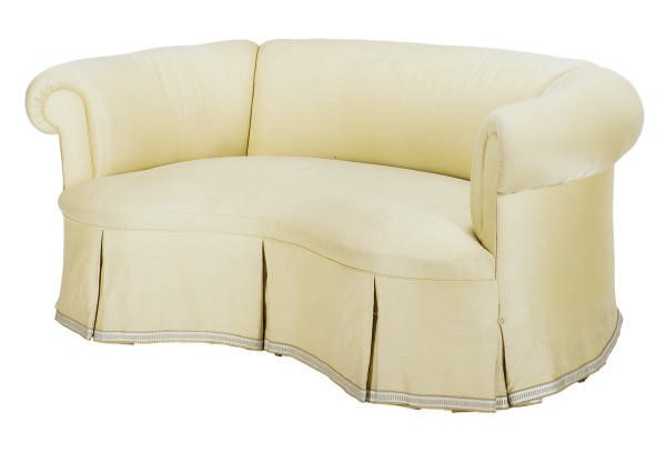 A CREAM-UPHOLSTERED CURVED SOFA,