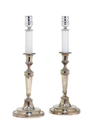 A PAIR OF SILVERED-METAL CANDLESTICKS MOUNTED AS LAMPS,