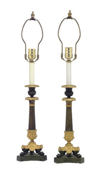 A PAIR OF PATINATED AND GILT-METAL CANDLESTICKS MOUNTED AS LAMPS,