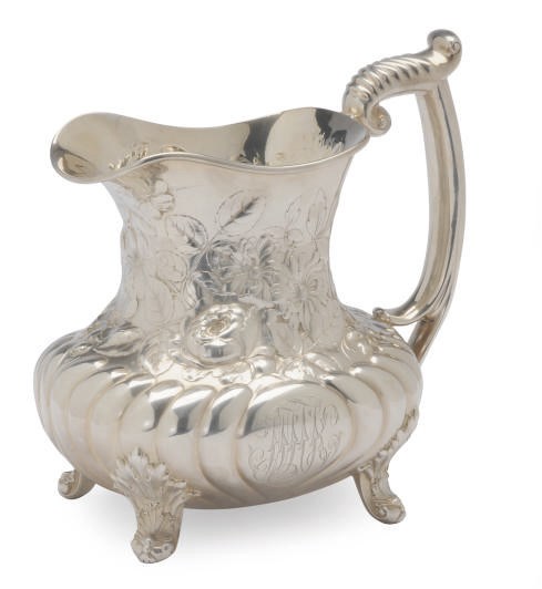 AN AMERICAN SILVER WATER PITCHER REPOUSSE WITH FLOWERS,