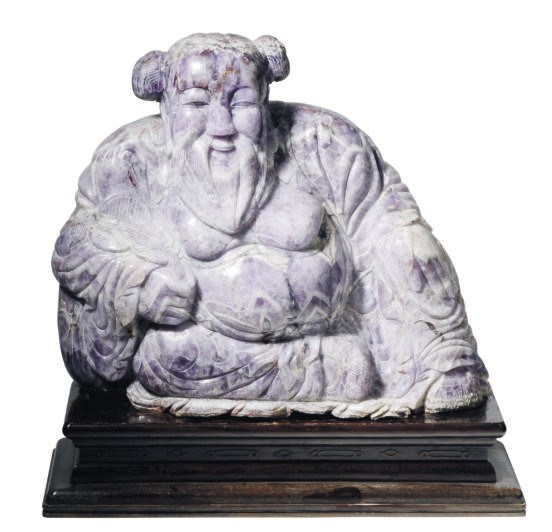 A CHINESE AMYTHEST OF A SEATED BEARDED IMMORTAL,