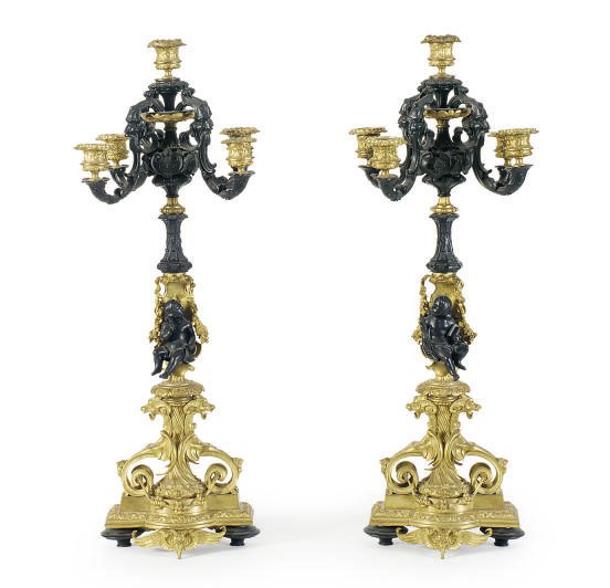 A PAIR OF PATINATED AND GILT-BRONZE FIGURAL FIVE-LIGHT CANDELABRA,