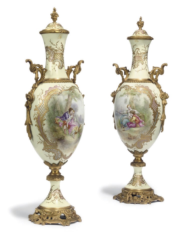 A PAIR OF ORMOLU-MOUNTED SEVRES STYLE IVORY-GROUND VASES AND COVERS