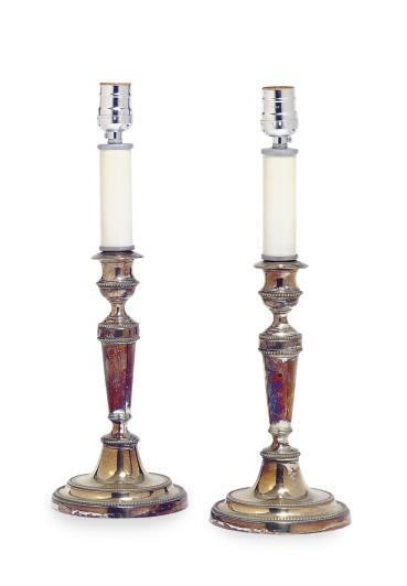 A PAIR OF SILVERED-METAL CANDLESTICKS MOUNTED AS LAMPS,