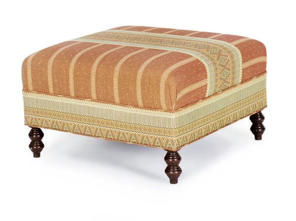 A STAINED WOOD AND UPHOLSTERED OTTOMAN,