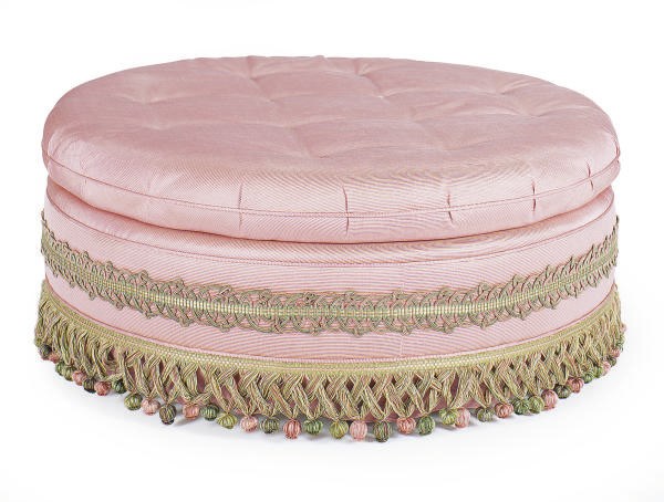A PINK UPHOLSTERED POUF,