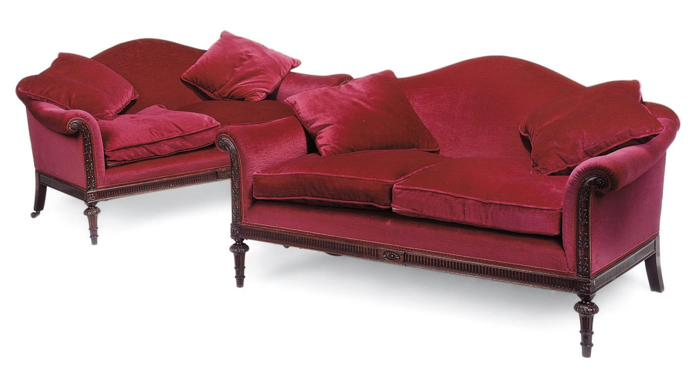 A PAIR OF MAHOGANY CARVED AND RED VELVET UPHOLSTERED SOFAS