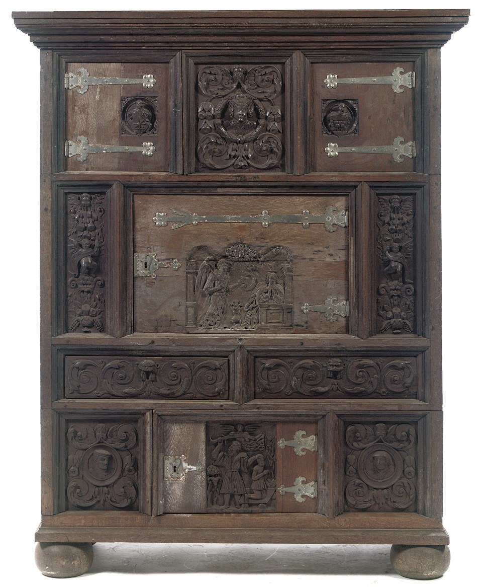 A GERMAN IRON-MOUNTED CARVED OAK CUPBOARD