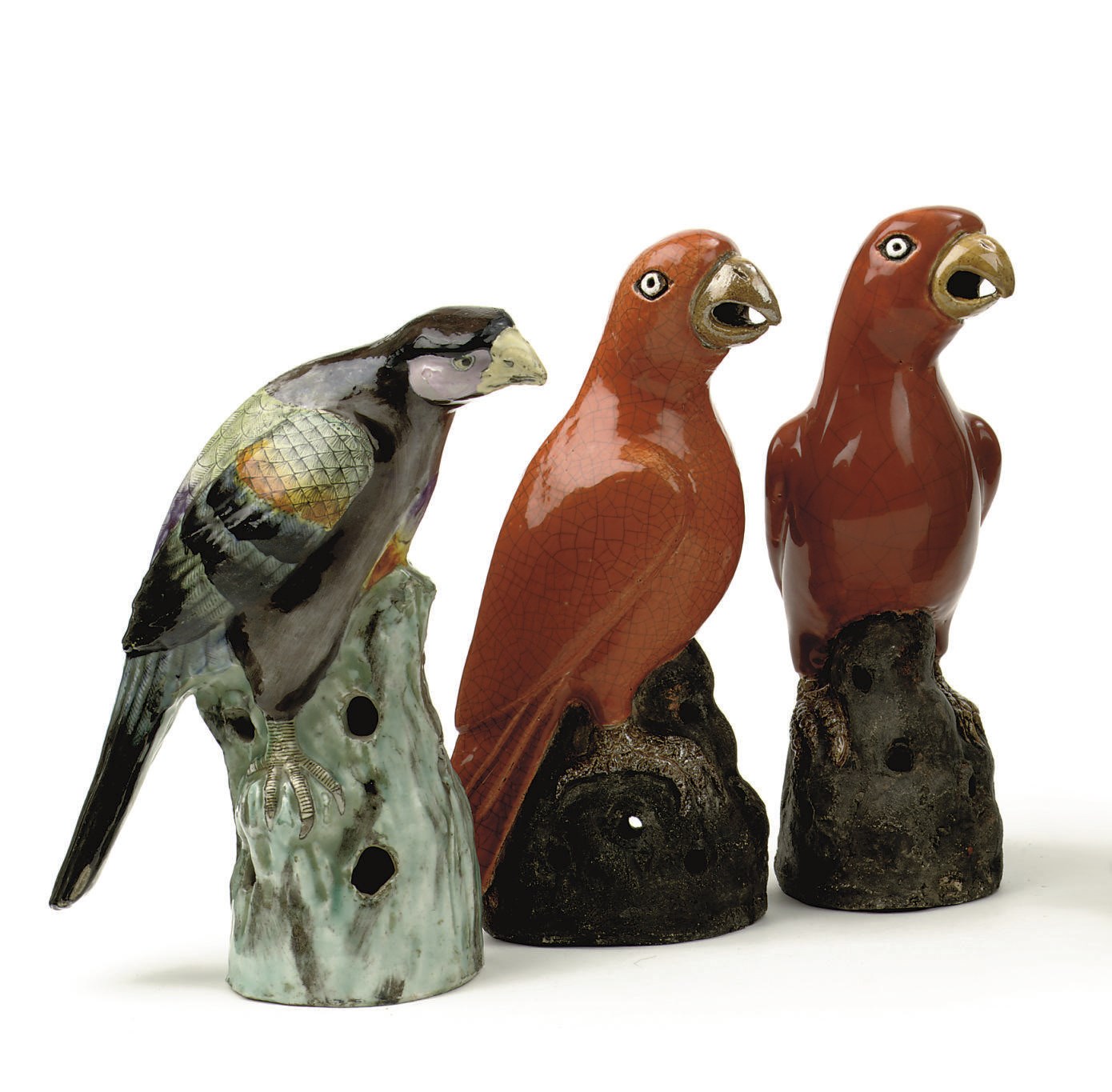 A Chinese famille rose figure of a hawk and a pair of orange-glazed parrots