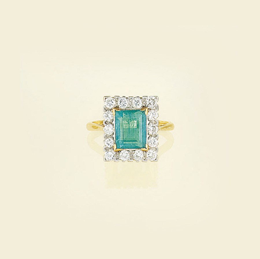 An emerald and diamond cluster ring