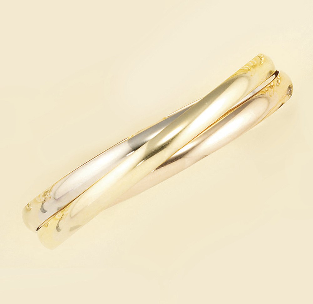 An 18ct. three colour gold triple hoop bangle, by Cartier