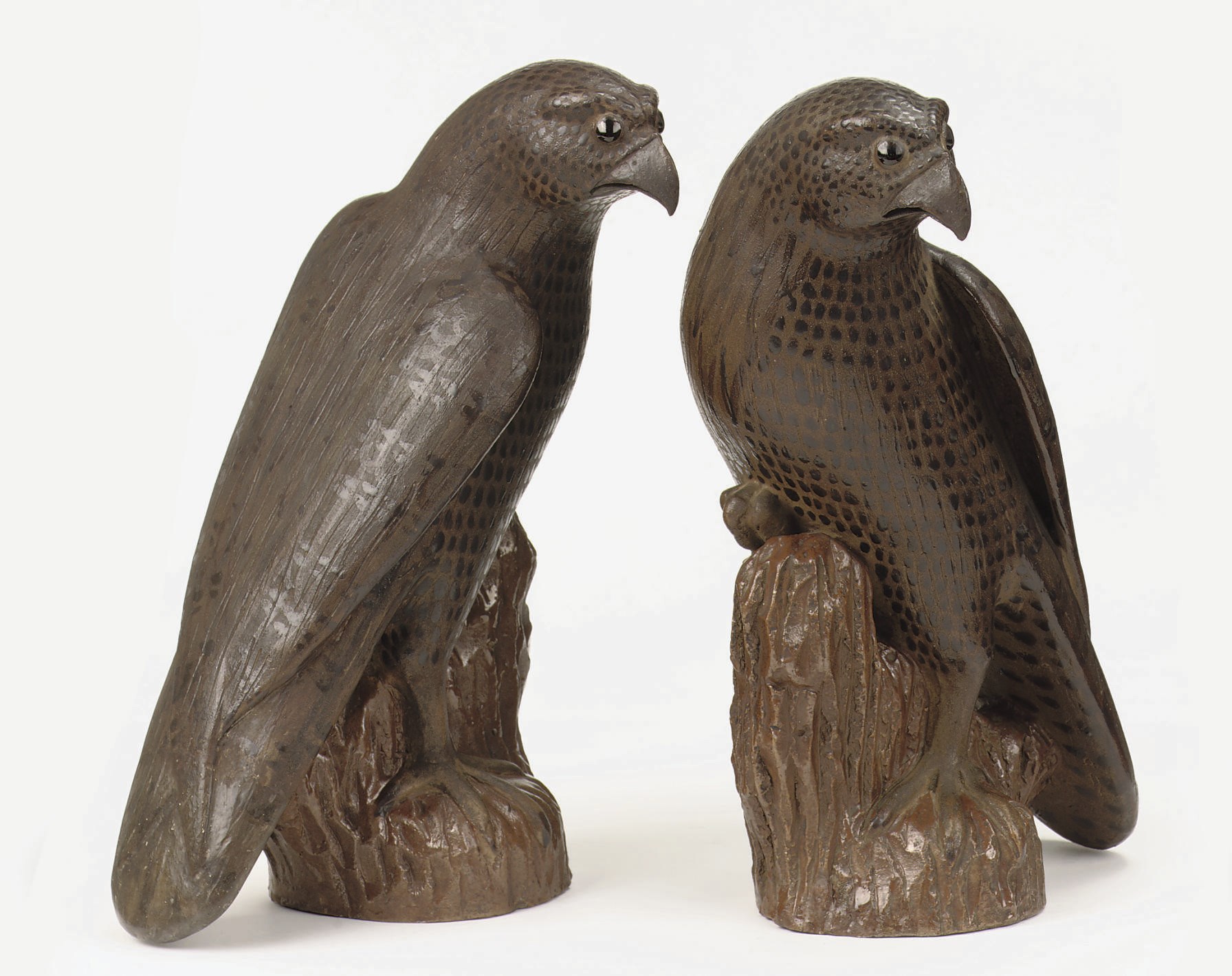 A pair of Chinese brown-glazed models of hawks