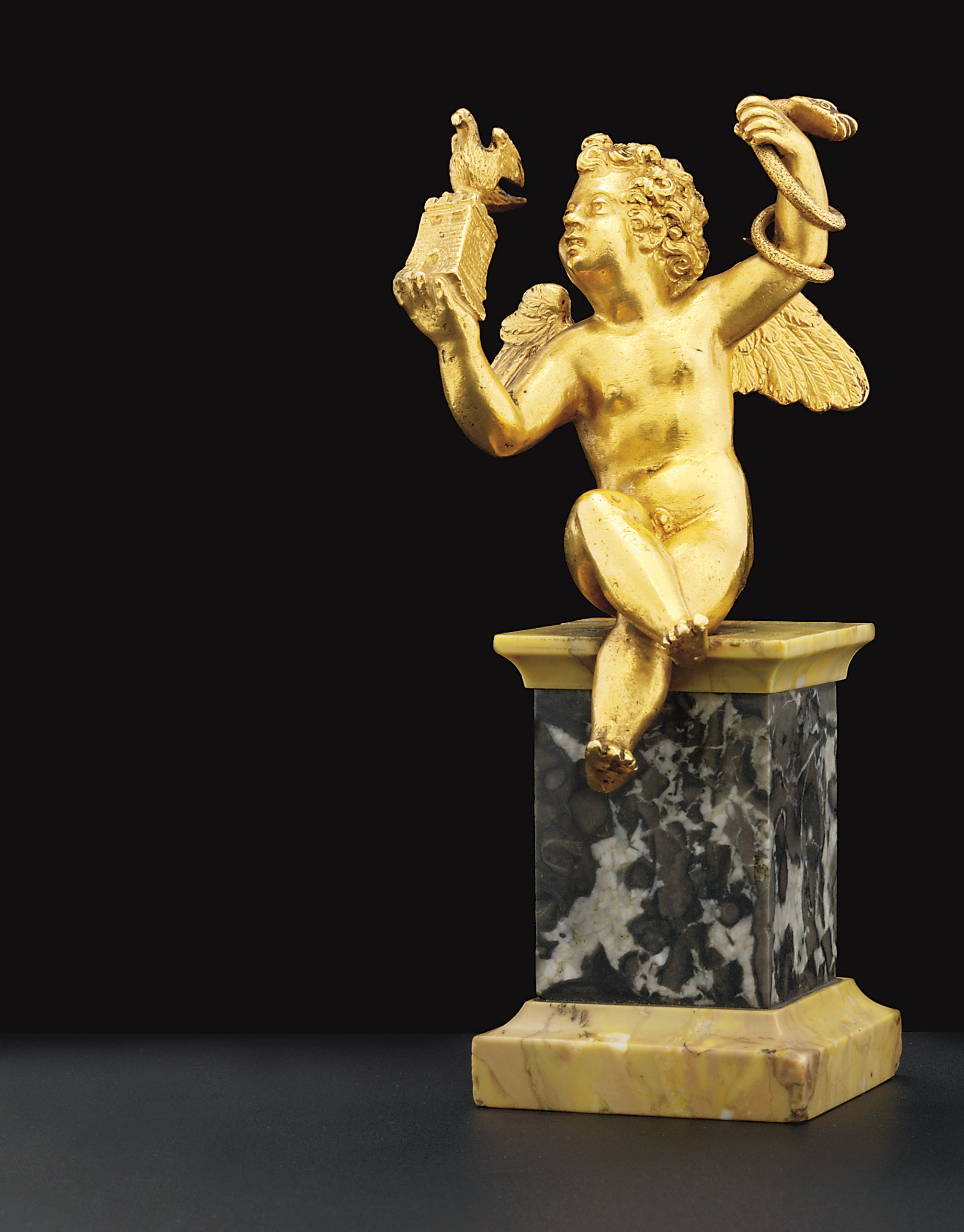 A GOLD FIGURE OF A SEATED PUTTO