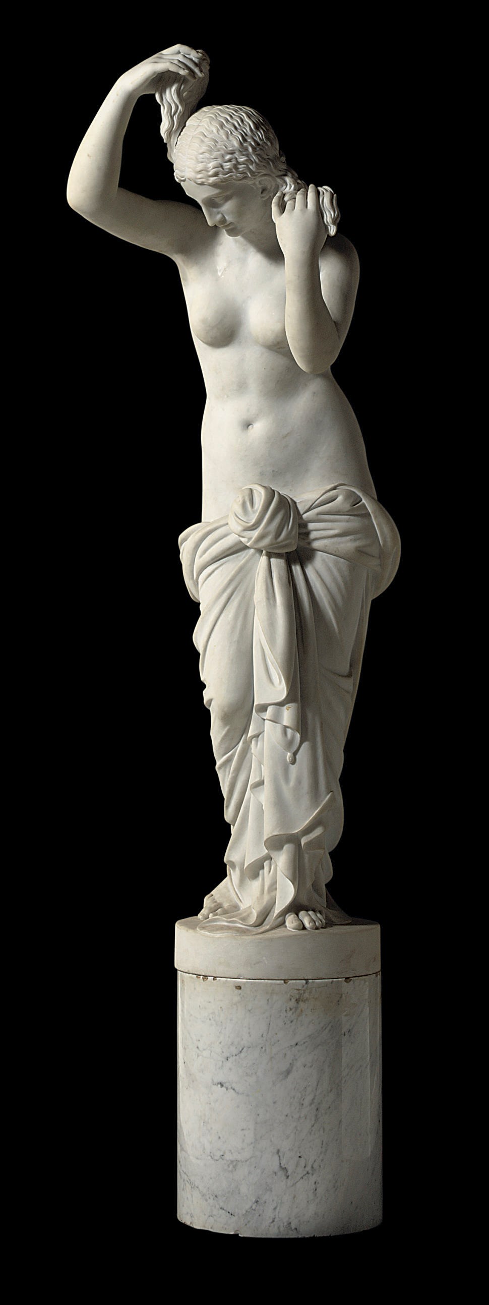 AN ITALIAN WHITE MARBLE FIGURE AFTER THE ANTIQUE OF APHRODITE ANADYOMENE