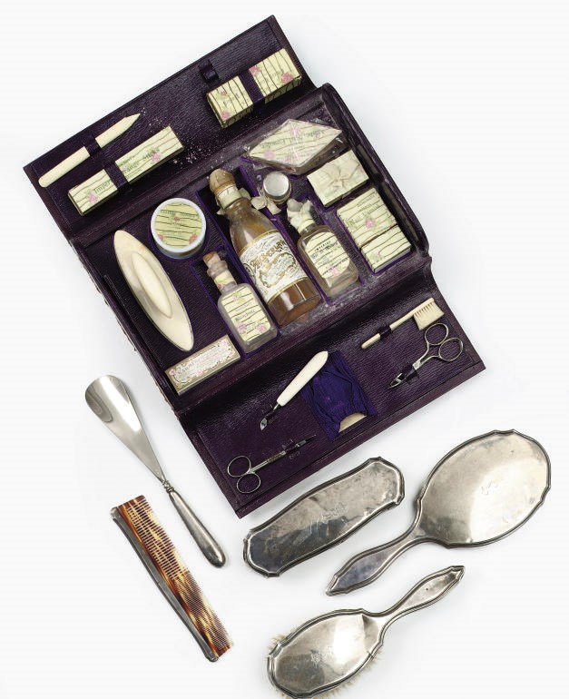 A Royal German silver-mounted brush-set, a mirror, a steel shoe-horn and a manicure set