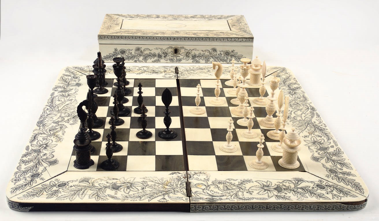 AN ANGLO-INDIAN IVORY, HORN AND SANDALWOOD CHESS SET, BOX AND BOARD