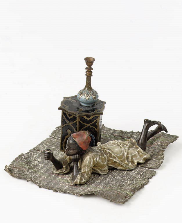 A VIENNESE COLD-PAINTED BRONZE FIGURE OF A MOORISH BOY SMOKING A CIGARETTE
