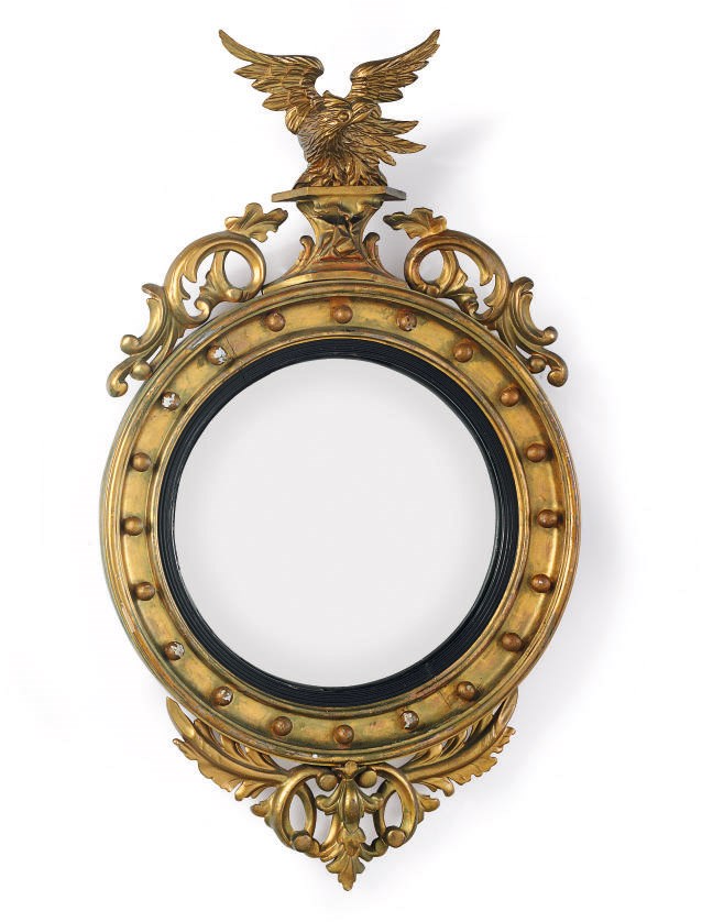 A CLASSICAL PART-EBONIZED AND CARVED GILTWOOD CONVEX LOOKING GLASS