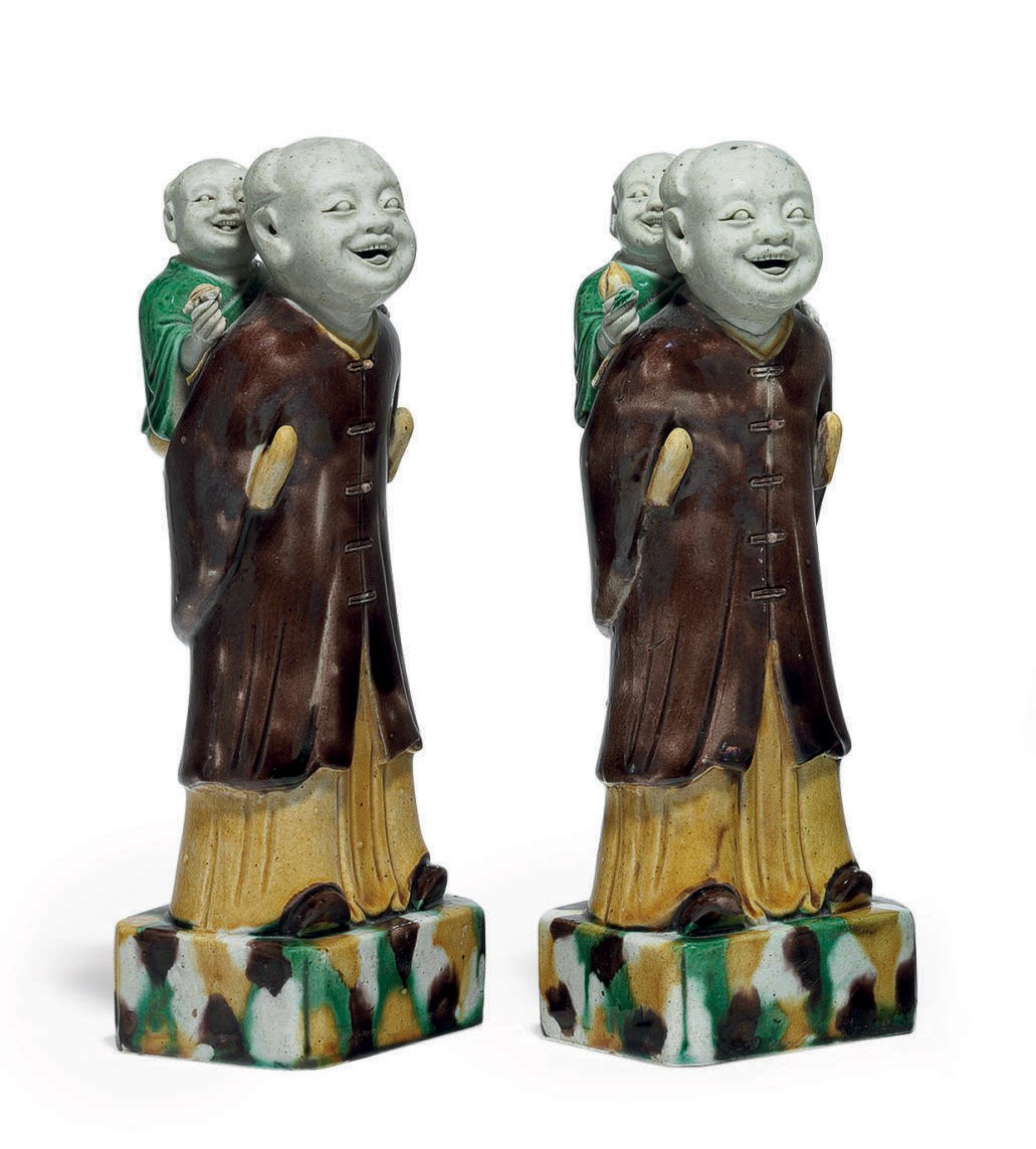 A PAIR OF BISCUIT-GLAZED FAMILLE VERTE PIGGYBACK GROUPS