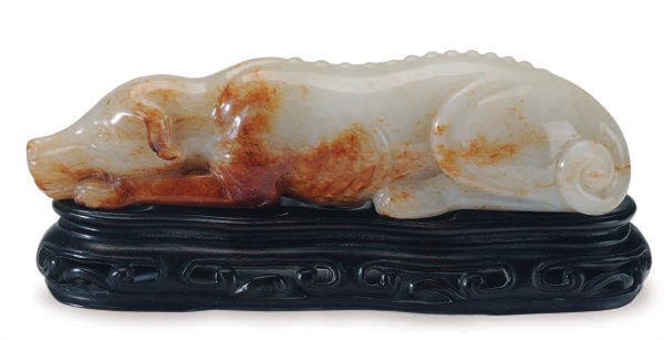 A CHINESE WHITE AND RUSSET JADE FIGURE OF A RECUMBANT HOUND